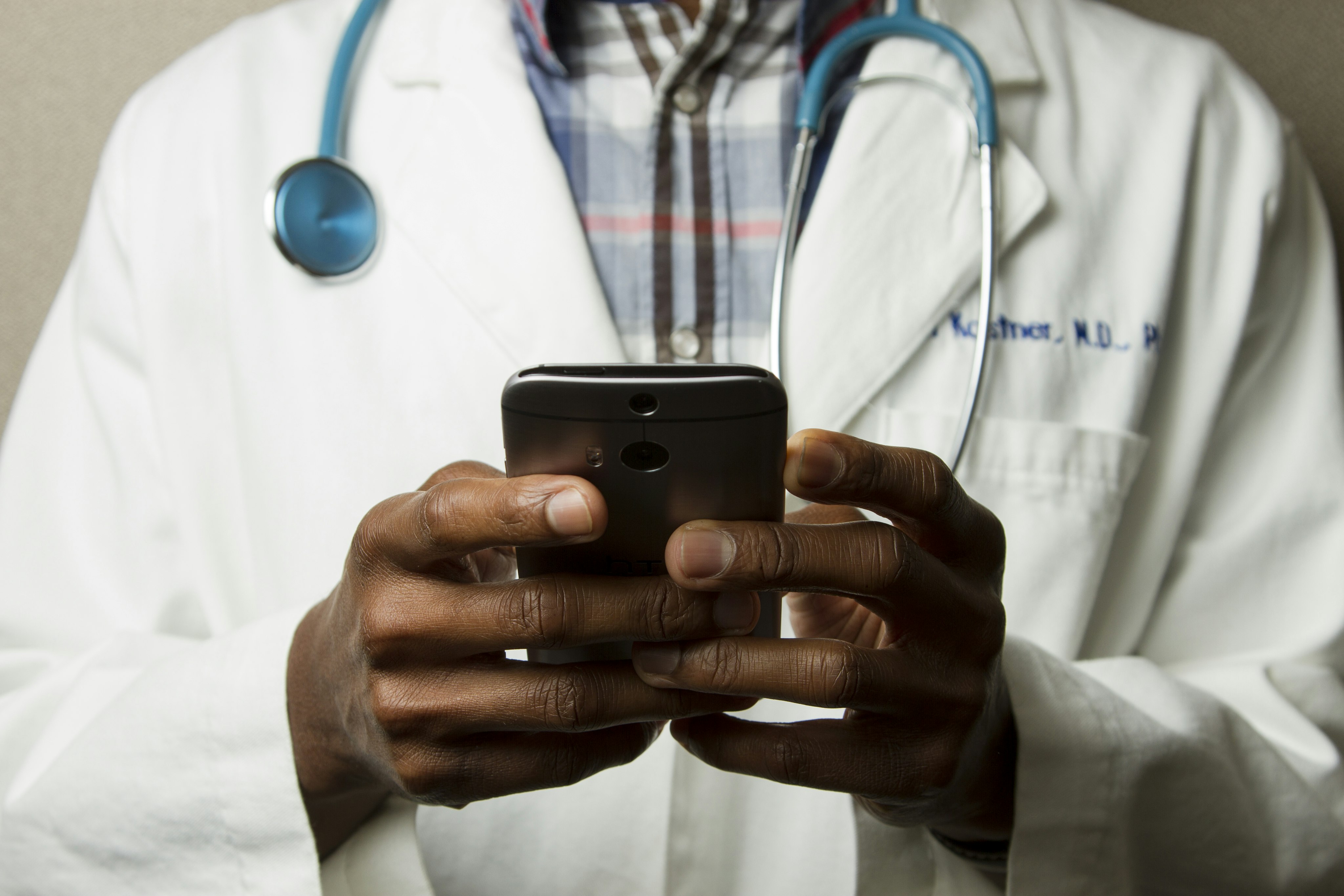 Médico utilizando celular